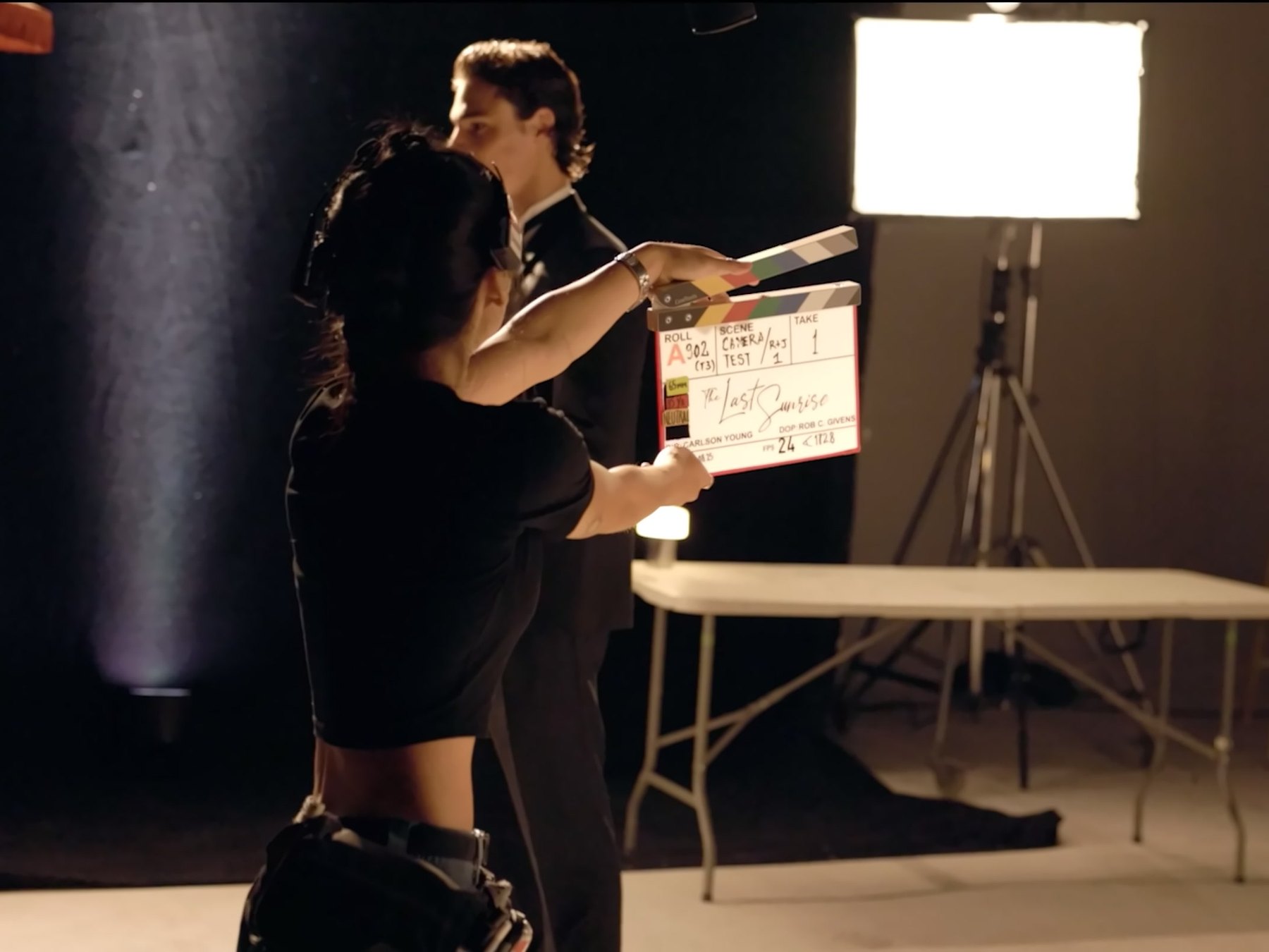 Behind-the-scenes still from The Last Sunrise, a clapperboard held up on a dark studio set